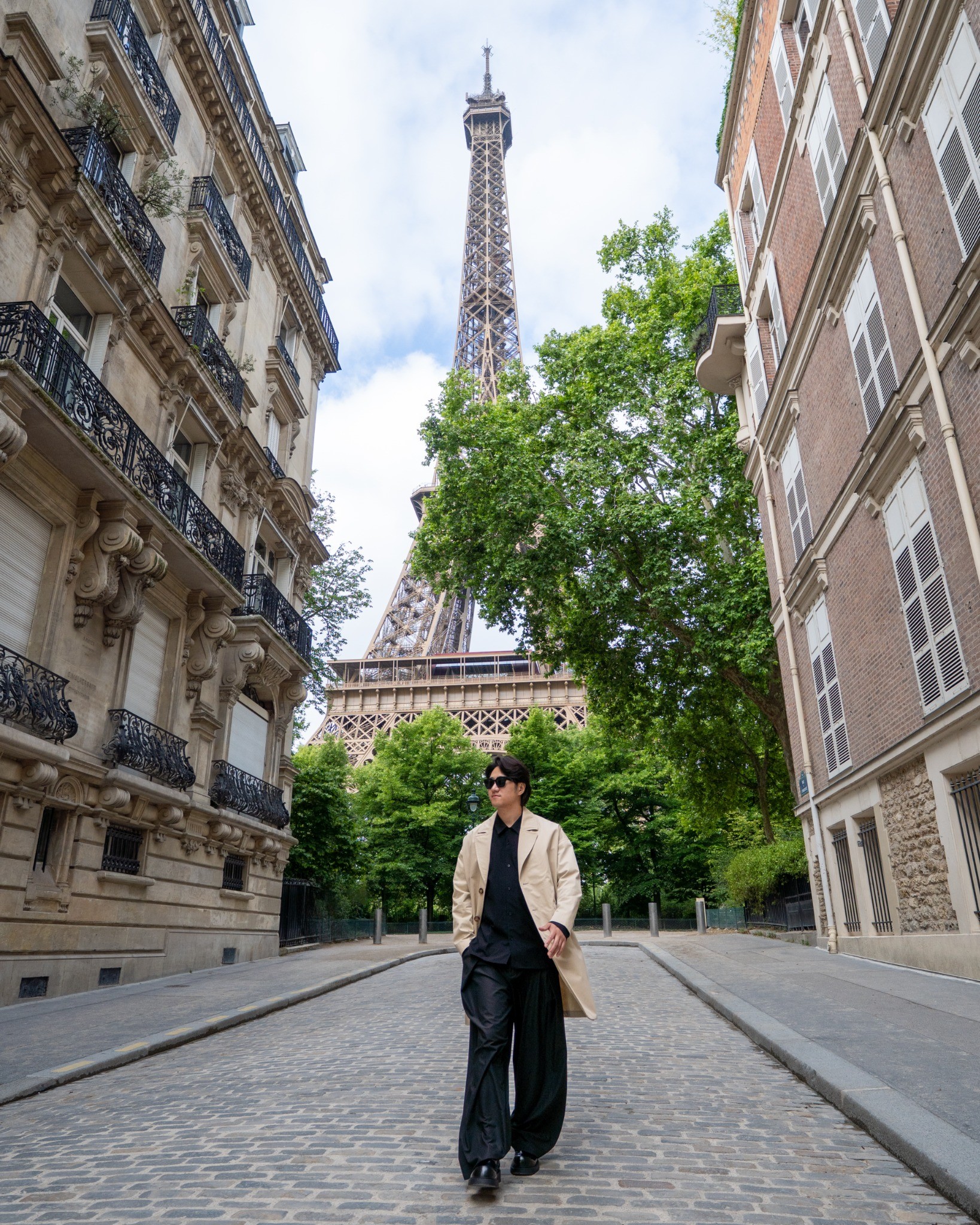 Solo traveler on a Paris street with the Eiffel Tower behind him